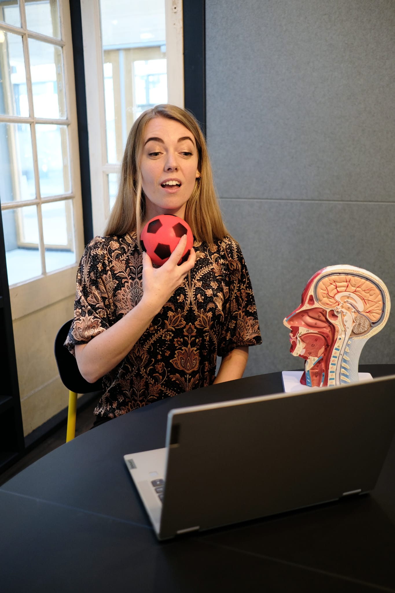 Elise demonstrating a speech exercise with a child-friendly ball